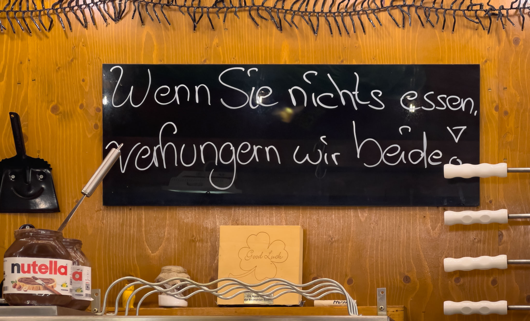 Fürther Kirchweih: Werbeschild "Wenn Sie nichts essen, verhungern wir beide!" in einem der Stände