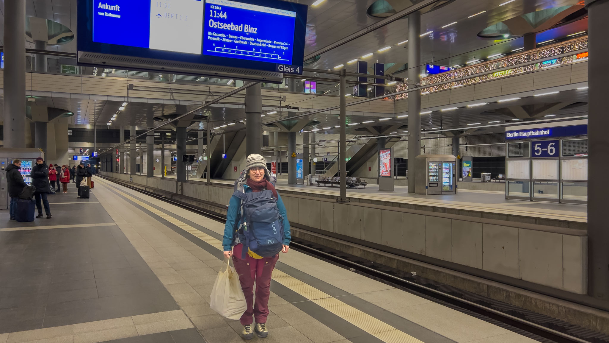 Maria am Berliner Hauptbahnhof unter der Anzeige nach Ostseebad Binz