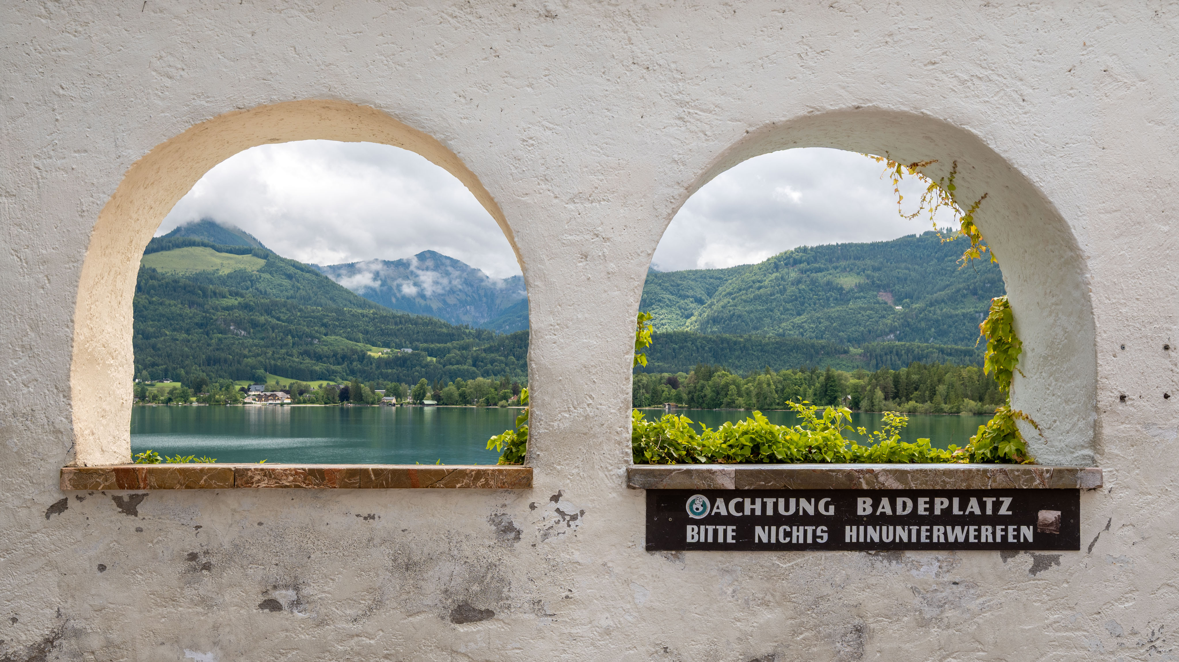 Blick durch zwei Mauerbögen in St. Wolfgang über den Wolfgangsee