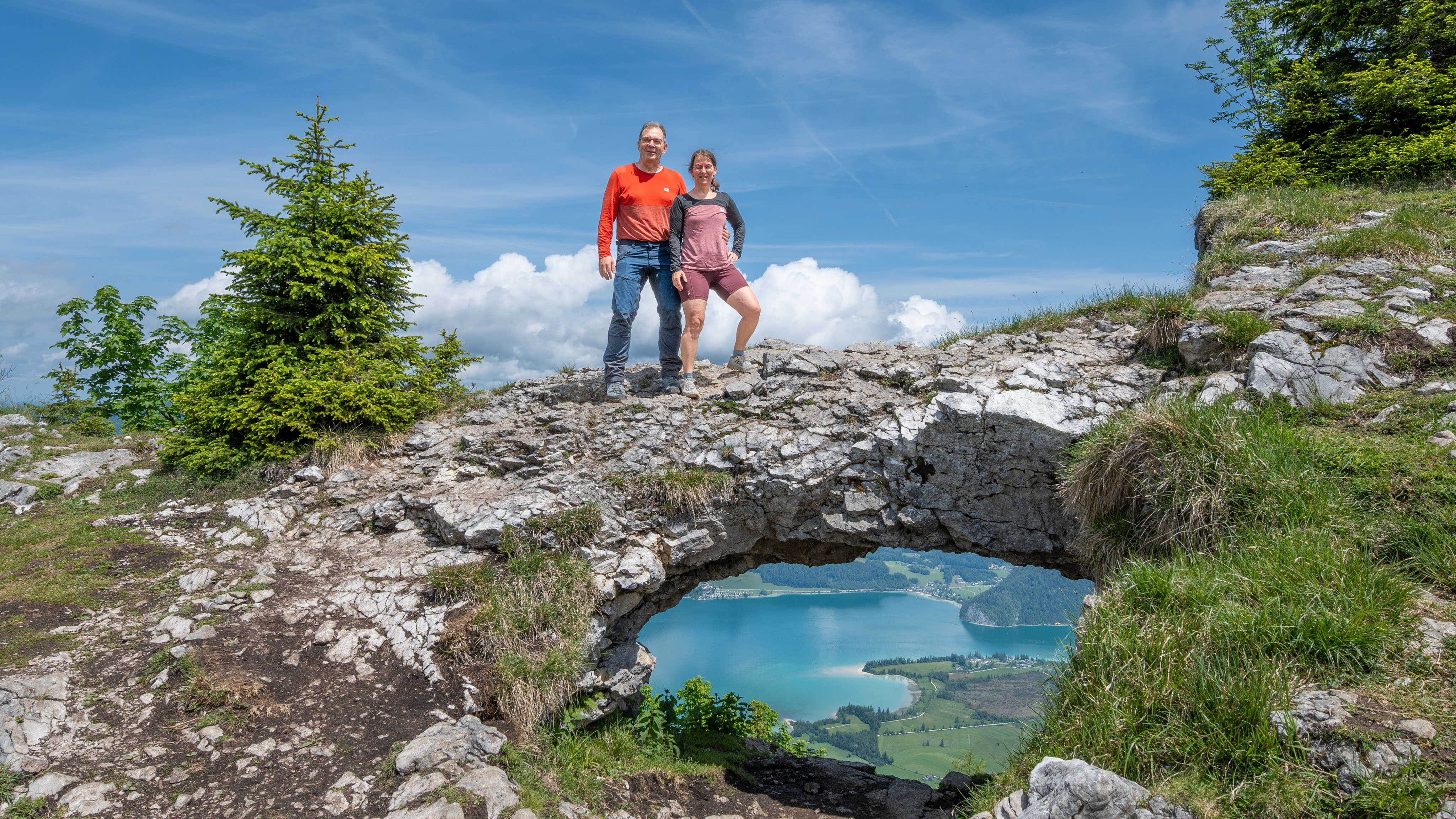 Thomas und Maria stehen auf dem "Bleckwand-Fenster", durch das man auf den Wolfgangsee schauen kann